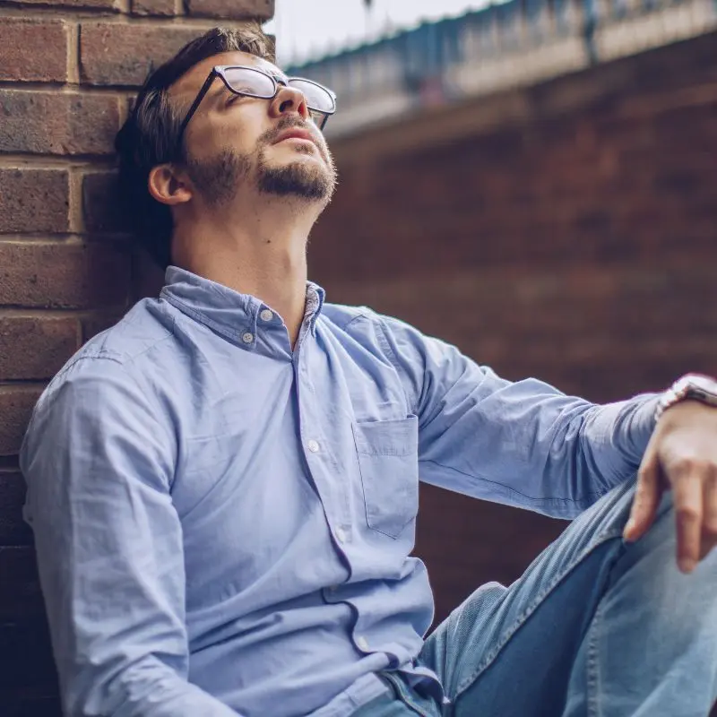 Hombre separado recostado en una pared pensativo, como melancólico, uno de los dolores de la persona del programa reconstruye tu vida después de una separación