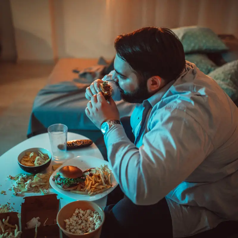 Hombre bastante joven sentado y comiendo.