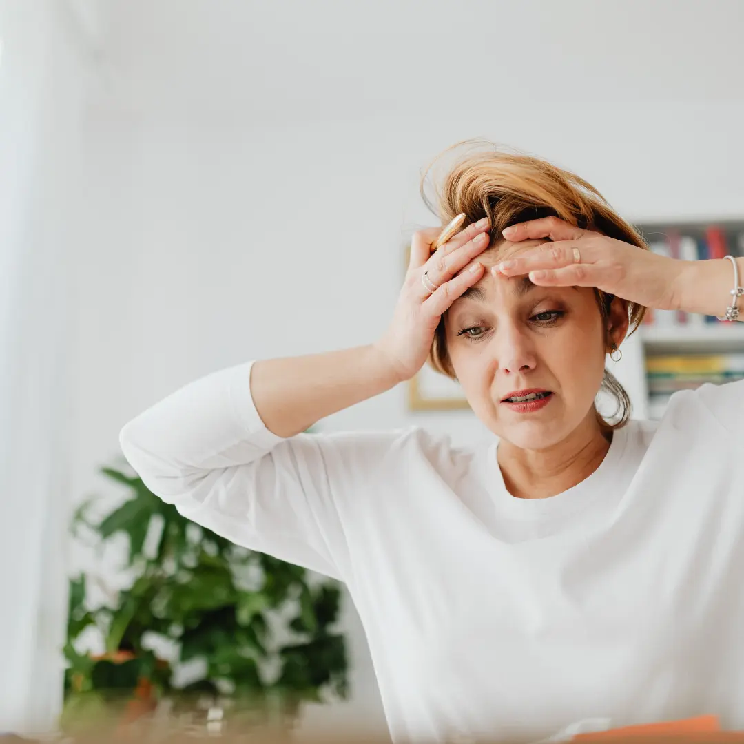 Mujer con las manos en la cabeza como perdida y abrumada